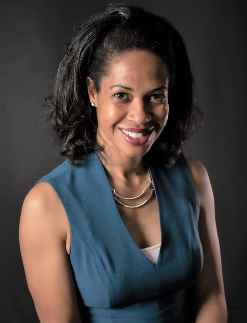 Smiling woman wearing a blue dress.